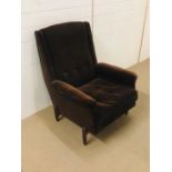 A mid century arm chair upholstered in brown velvet