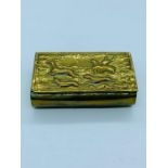 A brass snuff box depicting a hunting scene