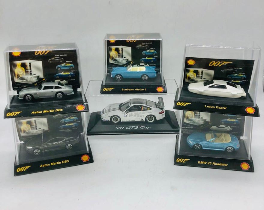 A selection of five Shell 007 model toy cars and a Porsche 911GT2 cup