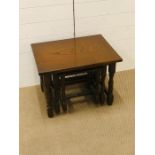 A nest of three dark oak cottage style tables