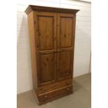 A modern pine wardrobe with hanging shelf and two lower drawers