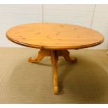 A round pine pedestal dining table