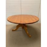 A round pine pedestal kitchen table