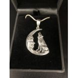 A Silver necklace in the form of a dog howling at the moon cased.
