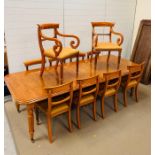 An extendable dining table on reeded legs with three leaves, eight splat back dining chairs and