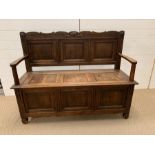 A carved monks bench (H98cm W128cm D48cm)