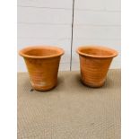 A pair of ribbed terracotta pots 31 cm High by 33 cm Diameter at top.
