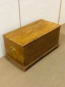 A pine blanket box with metal handles either end (H49cm D47cm W90cm)