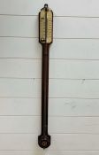 A wall mounted mahogany barometer.