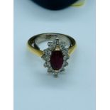 An 18ct yellow gold diamond and ruby cluster ring. Consisting of a heavy 18ct D section shank with