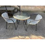 A rattan style bistro set with glass top and two chairs