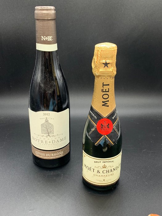 A bottle of Moet and Chandon champagne and a bottle of Notre and Dame Cotes Durhone France 2012