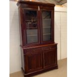 A mahogany bookcase with two glazed doors enclosing adjustable shelves, the base with a square edged
