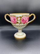 A Cauldon Ltd, two handled chalice style cup. Hand painted with a rose theme. (H18cm)
