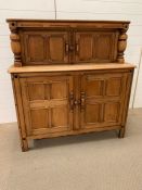A light oak sideboard with cupboard top and bottom and turned decorative pillars to side. (H124cm