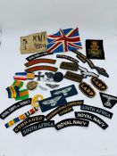 A selection of militaria insignia and reproduction WW1 Germany badges and cloth badges.