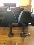 A pair of bonze coloured table lamps with black shades with bronze interior and leaf pattern