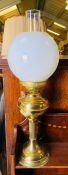 A brass oil lamp with glass shade