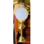 A brass oil lamp with glass shade