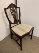 A shield back chair with fleur-de-lis carved to back and square tapering to legs