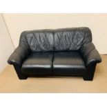 A two seater black leather sofa