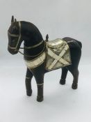 A decorative wooden horse featuring brass, white metal and shell decoration