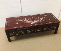 A Low Chinese coffee table with mother of pearl design. (H42cm W128cm D50cm)