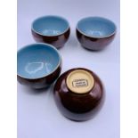 Four Denby dishes with light blue inside glaze