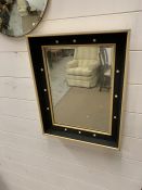 A square mid century wall mirror with cream spot details to frame