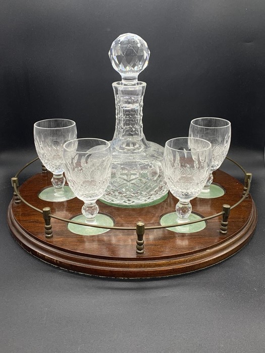 A Cut Glass Decanter set with four glasses on a Mahogany Stand.