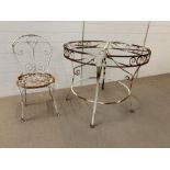 Salvaged scroll work circular table and metal work chair with lattice seat