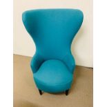 A high back sculptural seat, upholstered in a aqua blue wood fabric possible by Tom Dixon,