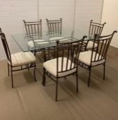A metal framed dining table with glass top and six chairs (H78cm W168cm D106cm)