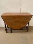 A gate leg oval mahogany dining table with barley twist legs