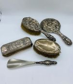 A selection of four silver backed dressing table items.