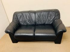 A two seater black leather sofa
