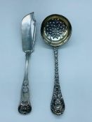 A silver sugar sifter and fish knife