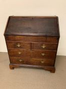 A mahogany bureau, fall flap enclosing an interior of cupboards, pigeon holes and drawers, with