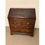 A mahogany bureau, fall flap enclosing an interior of cupboards, pigeon holes and drawers, with