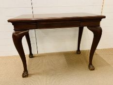 A mahogany writing desk with drawer to centre on ball and claw feet (H76cm W104cm D58cm)