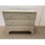 A painted three drawer chest of drawers with bun handles (H94cm W105cm D55cm)