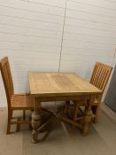 A square extendable pine farmhouse kitchen table and two teak chairs 76 cm H x 90 cm W x 93 cm (