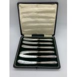 A Box of hallmarked silver butter knives.