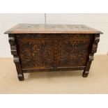 A two panel coffer with hinged lid with carved detailing to front and top (H60cm W80cm D46cm)