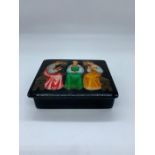 Papier Mache black lacquer Russian box painted with three ladies seated on benches (H8cm W10cm D2.