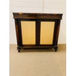 A Rosewood Chiffonier with a pair of doors to front with silk panels, flanked by turned columns