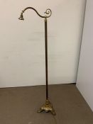 A floor standing brass reading lamp on a brass cast tripod base (H167cm)