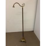 A floor standing brass reading lamp on a brass cast tripod base (H167cm)