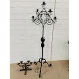 A large wrought iron floor standing candelabra and a table top candelabra