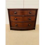 A bow fronted chest of drawers, flanked by reeded columns with bun handles (H80cm W98cm D54cm)